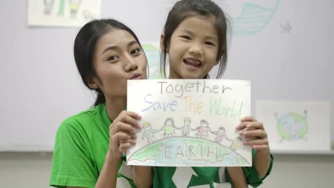 小女孩和老师的肖像，穿着绿色生态t恤，拿着她关于拯救世界项目的图纸。志愿者、自然和教育理念。