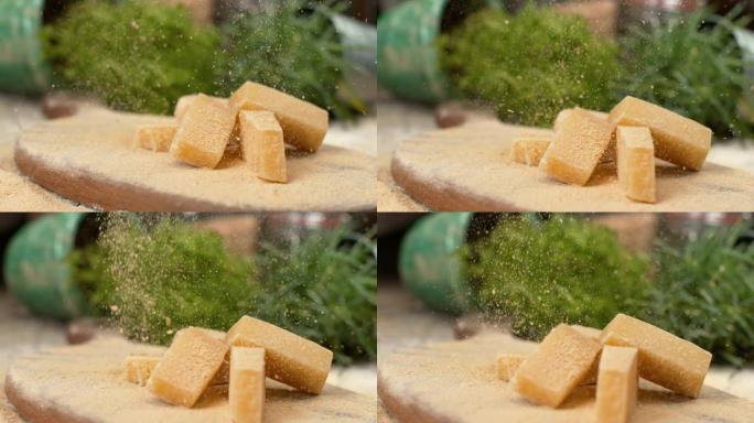 慢动作: 帕尔玛片落在木板上的奶酪块上。
