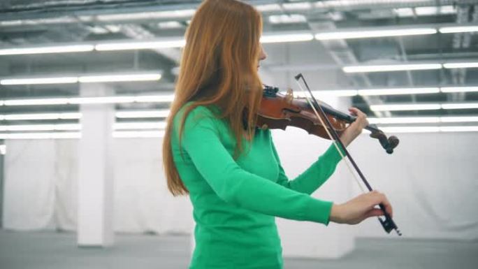 红发女人在空荡荡的大厅里熟练地拉小提琴