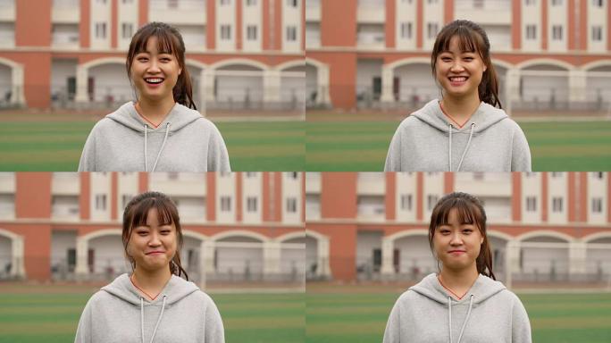 年轻的亚洲女孩在校园里对着镜头微笑的肖像