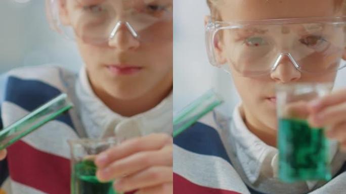 化学课上可爱的小男孩混合化学物质和烧杯，学习更多关于科学的知识。垂直屏幕方向9:18的视频素材