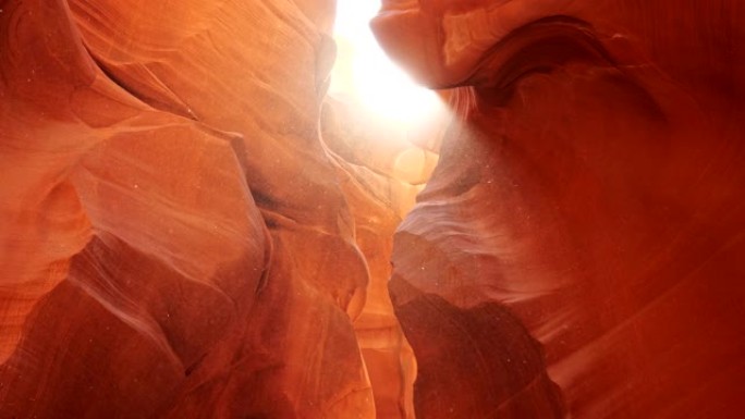 美国羚羊峡谷橙色岩石周围漂浮的灰尘。阳光穿过，到处闪耀。Steadicam镜头，4K
