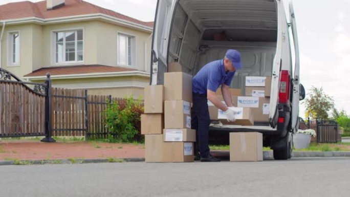 邮政服务人员将包裹装入货车