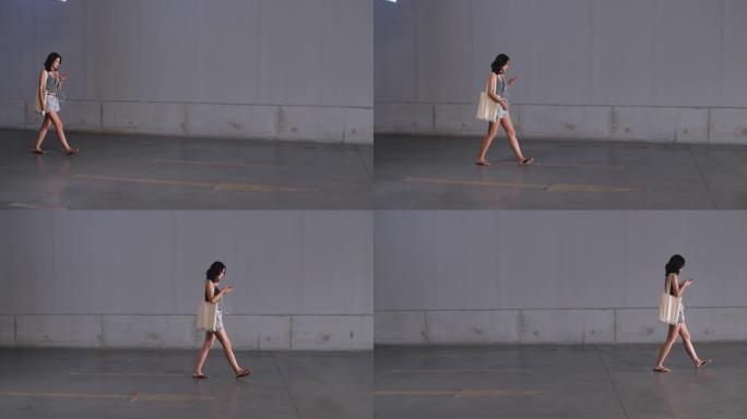 年轻亚洲女子看手机走路，4k