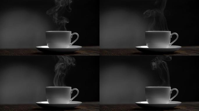 在黑色和灰色背景的木桌上喝杯咖啡。蒸汽来自站在碟子上的杯子。慢动作镜头