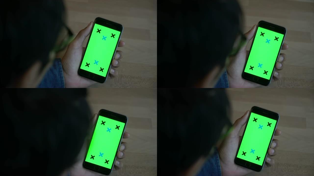 男性手握智能手机绿屏特写