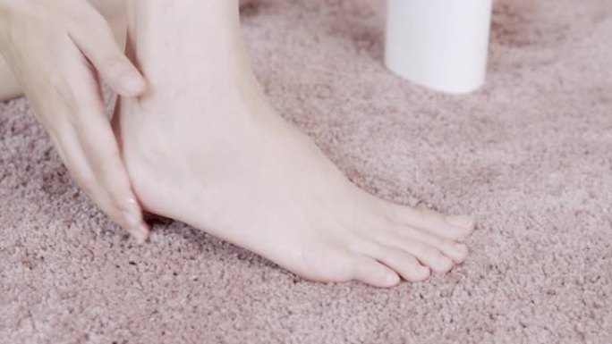 亚洲成年女性用手在脚上涂抹保湿霜。身体护理概念。