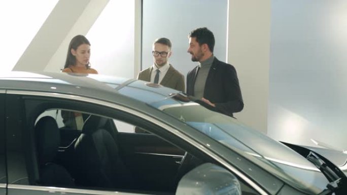 男女买家与汽车经销商经理讨论汽车