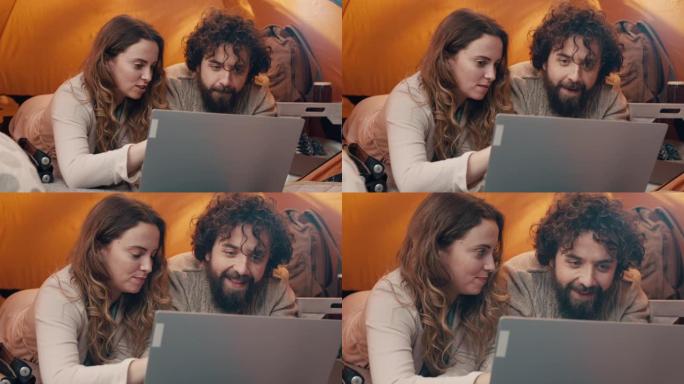 情侣在野营旅行中使用笔记本电脑
