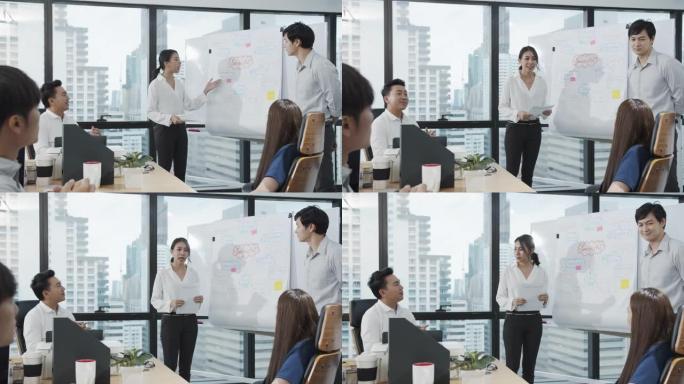 4K UHD: 亚洲妇女在会议室向同事介绍数据。