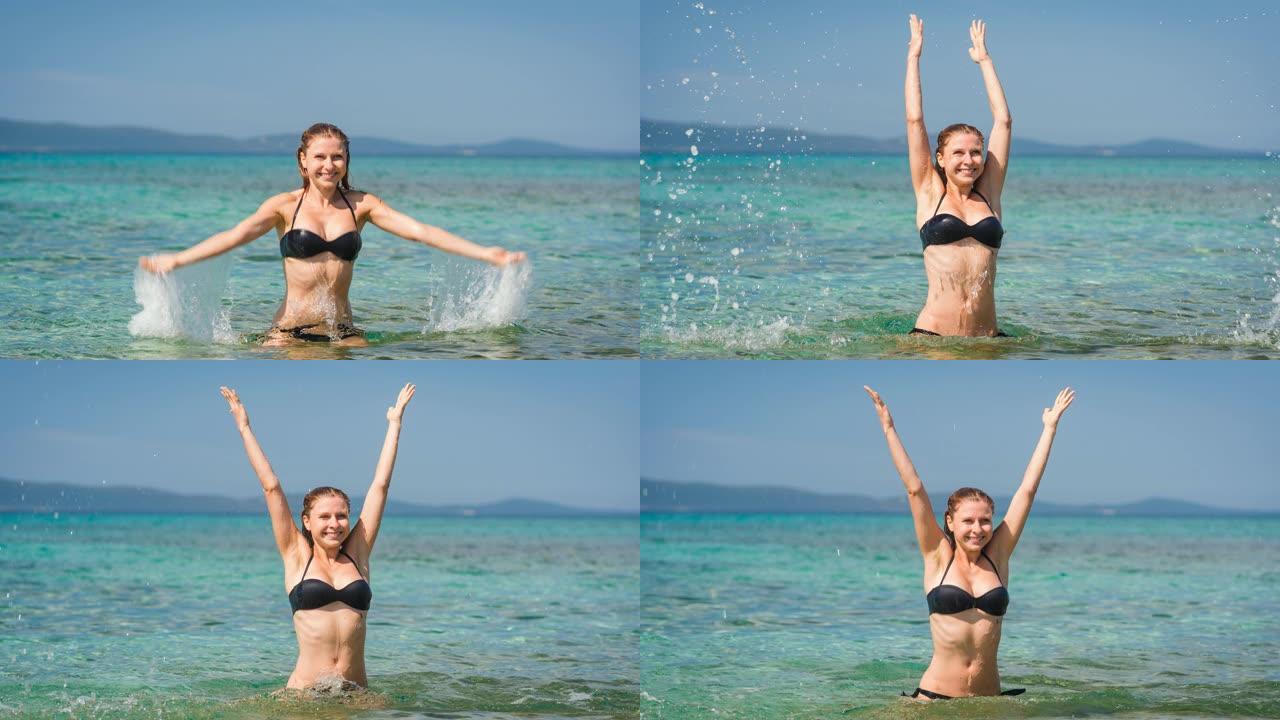 女人在海边度假，在绿松石色的海洋中游泳，泼水