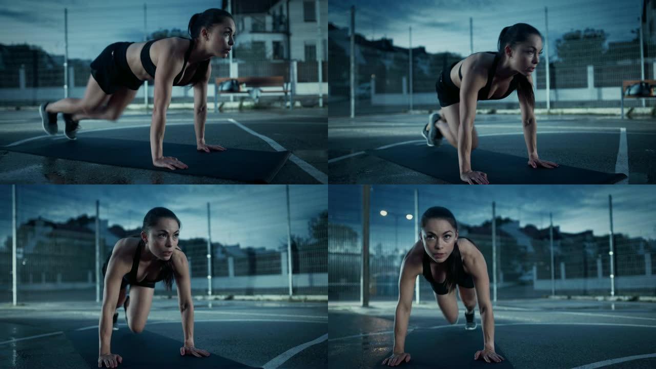 美丽精力充沛的健身女孩做登山运动。她正在一个有围栏的室外篮球场里锻炼身体。居民区下雨后的晚间录像。