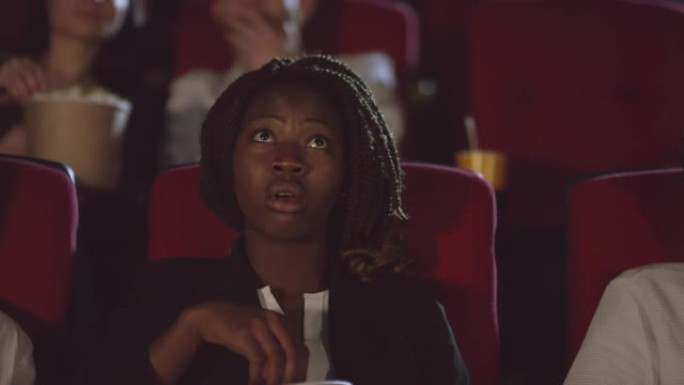 黑人妇女在电影院观看激动人心的电影