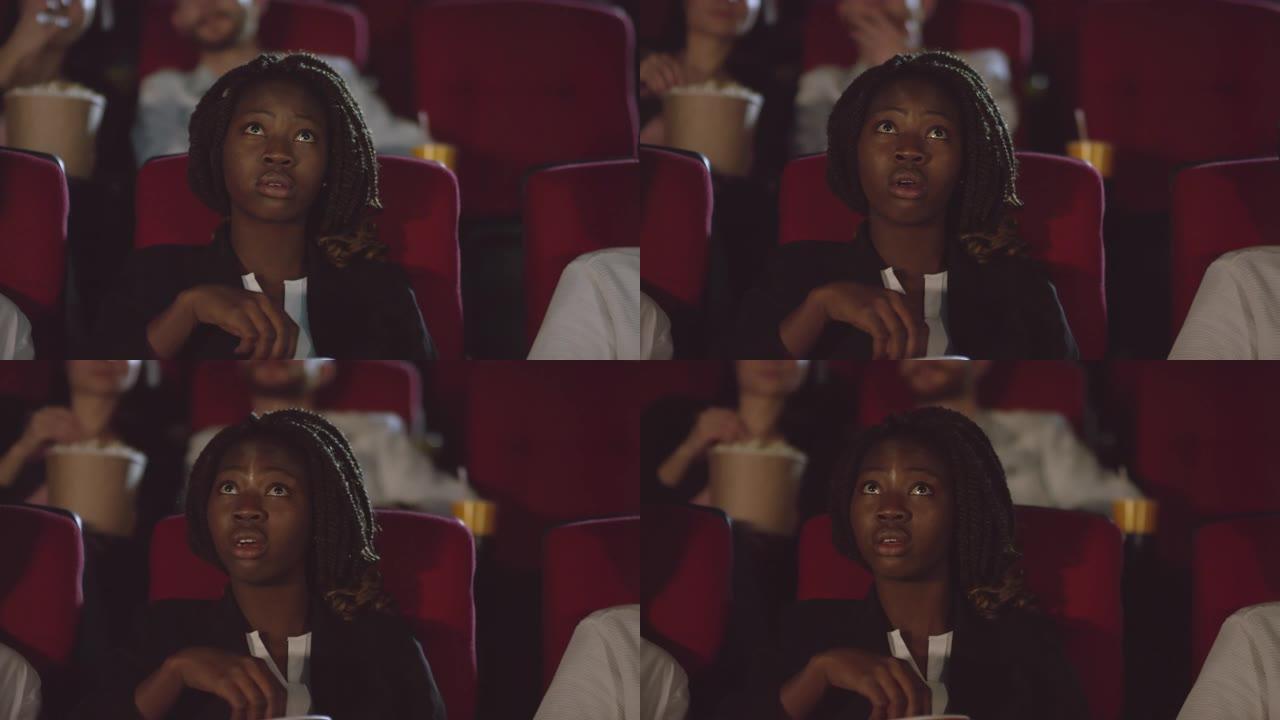 黑人妇女在电影院观看激动人心的电影
