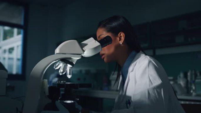 深色皮肤的肖像女科学家正在实验室用显微镜分析样本以提取DNA和分子