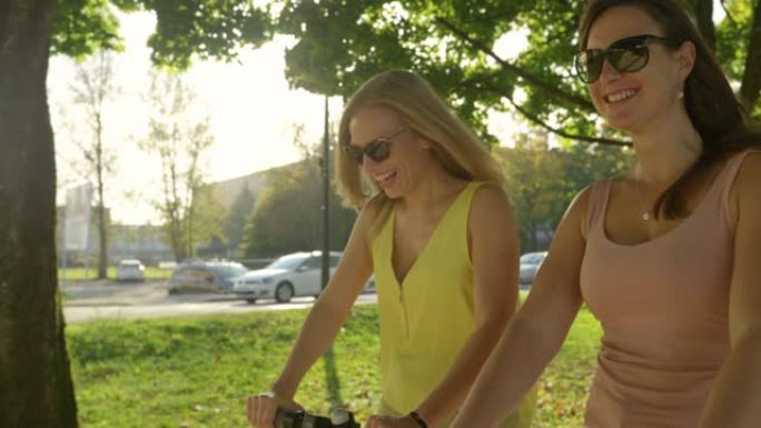 特写: 开朗的女性朋友在骑电动滑板车时谈笑风声。