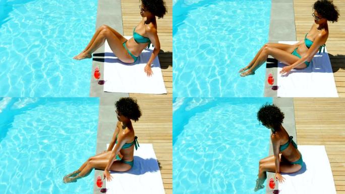 年轻黑人妇女在游泳池4k泡脚的侧视图