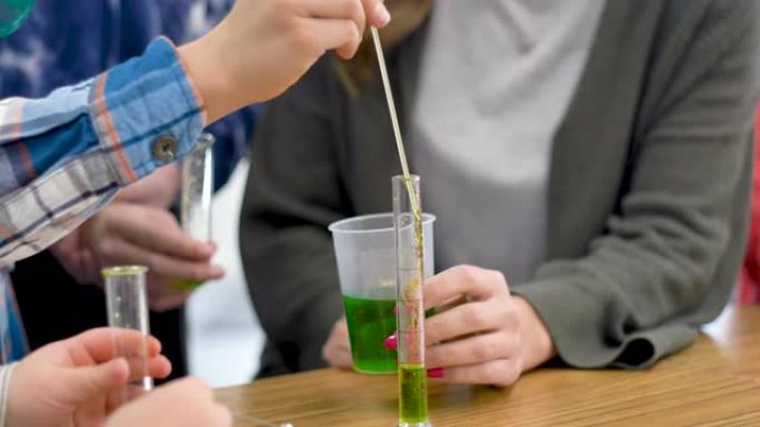 老师和学生在教室里做化学实验。
