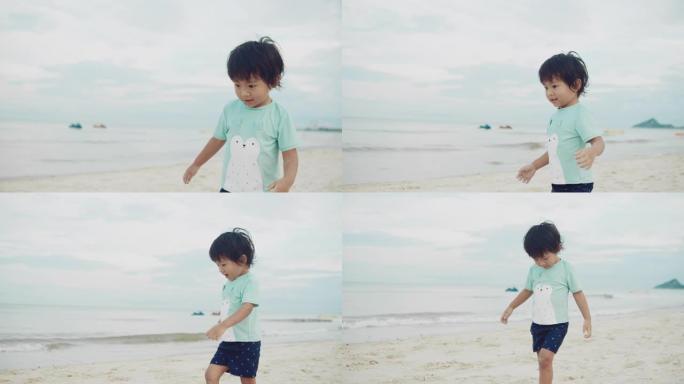 小男孩赤脚走在白沙海岸