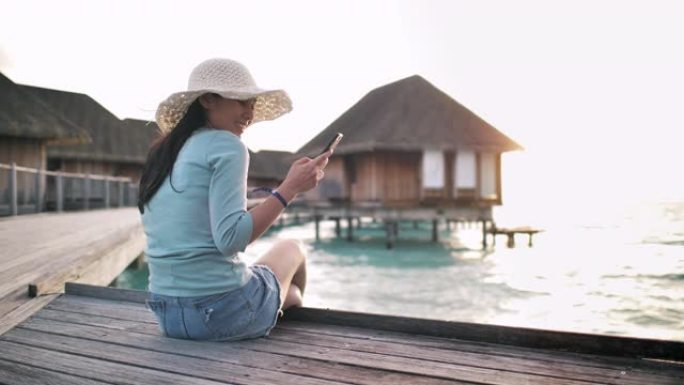 在海滩度假胜地使用智能手机的女人