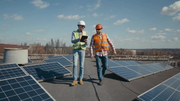 工程师和技术人员在太阳能电池板之间讨论