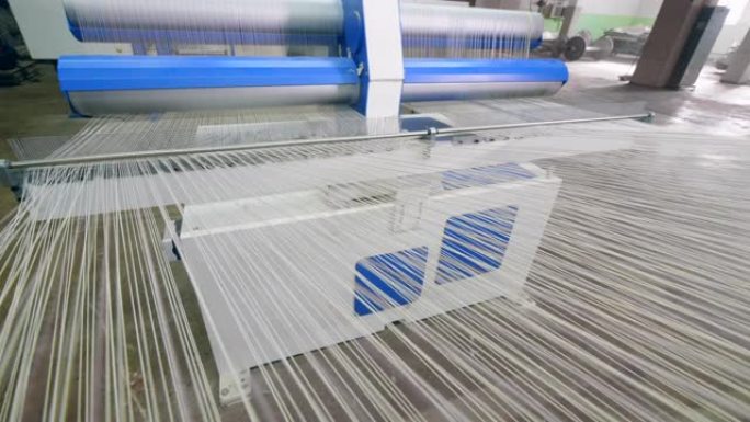 纺织厂的专用织机上编织的白色织物。