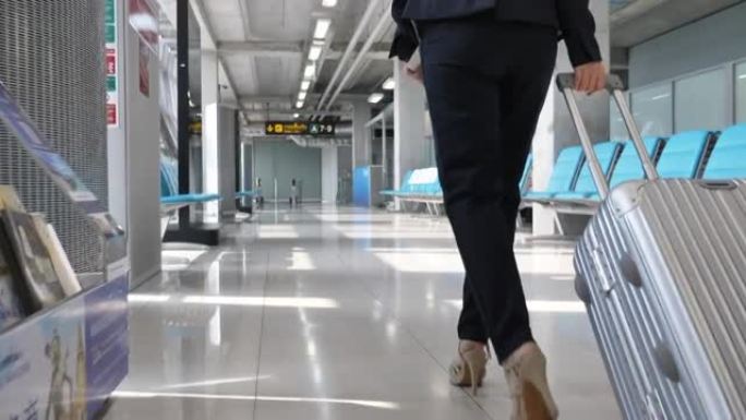 女商人带着手提箱在机场散步，商务旅行