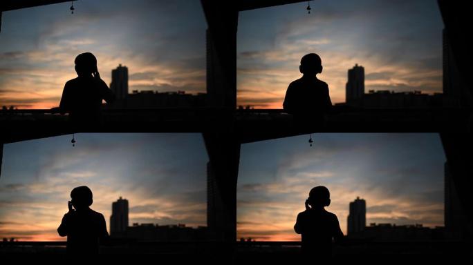 日落时分，亚洲中国中年妇女在阳台上戴着无线耳机听音乐