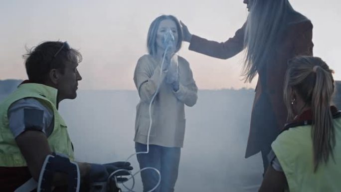 护理人员为事故的一名年轻女孩提供急救氧气面罩。专业人士拯救生命。到处冒烟