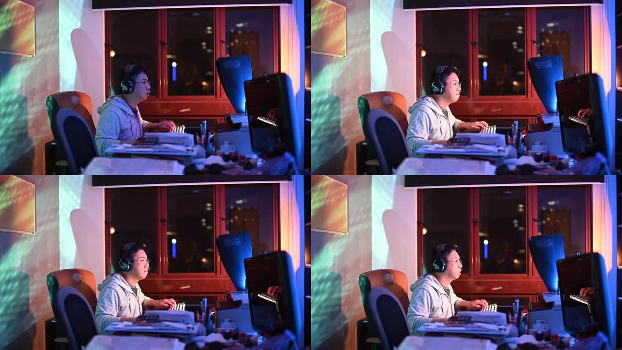 一名亚洲中国中年男性在家在书房玩电脑游戏，耳机在线与队友交谈