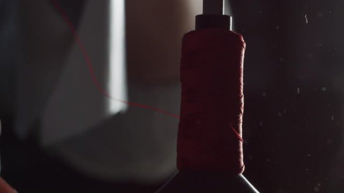 根据意大利的传统，鞋匠使用缝纫机缝制红色皮革的特写镜头。