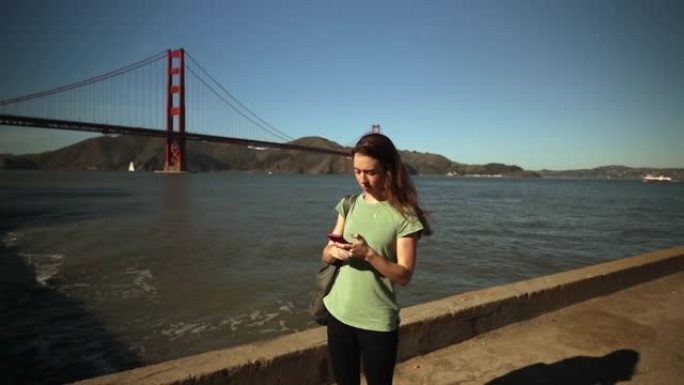 金门大桥上使用智能手机的女人