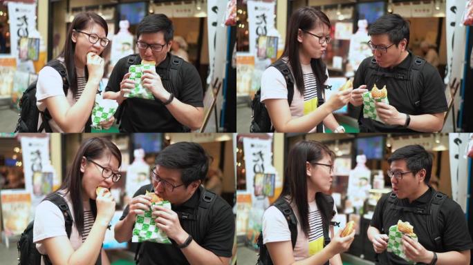 朋友旅游在东京街头食品市场吃羊角面包Taiyaki (日本鱼形蛋糕)