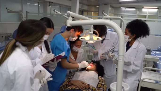 一群学生在做牙科手术时观察同学，对患者和老师进行监督