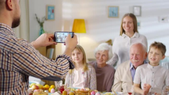 男子在智能手机上拍摄家人的照片