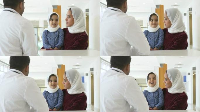 男医生向一位年轻的病人和她的母亲解释如何注射胰岛素