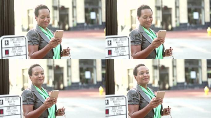 城市中的非裔美国妇女在街角发短信