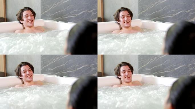 年轻的白人男子在热水浴缸里大笑