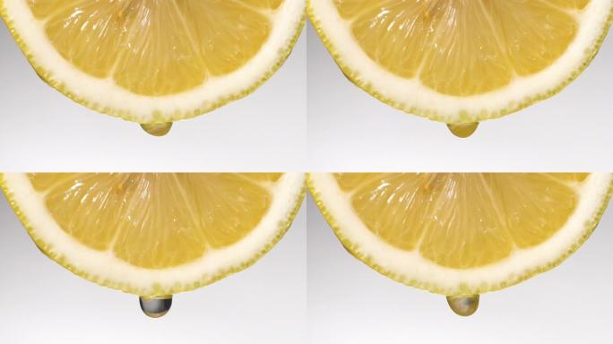 慢动作: 柠檬片上的许多液体掉落在白色上