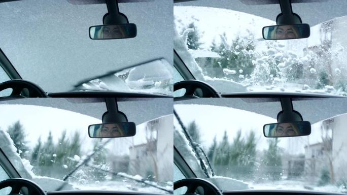 司机的视点。汽车刮水器清洁窗户上的雪