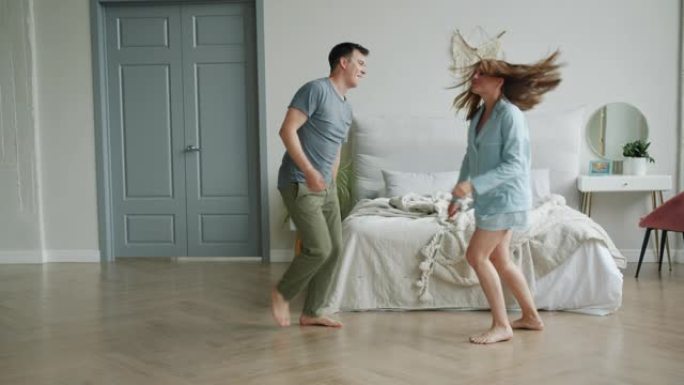 穿着睡衣的男人和女人在卧室里跳舞，享受音乐