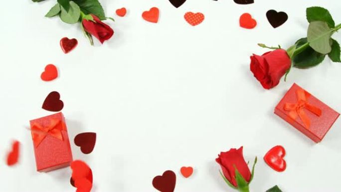 圆形4k白色表面的红玫瑰、礼品盒和五彩纸屑的心形