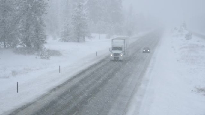 半卡车和汽车在恶劣的天气条件下沿着下雪的道路行驶。