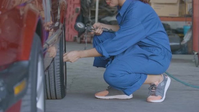 职业女机械师在车库修理汽车。汽车服务理念。
