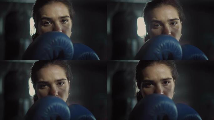 一位美丽健康的黑发跆拳道运动员在镜头前摆姿势，双手戴着蓝色战斗手套。她棕色的眼睛反映了自信和决心。她