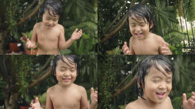 快乐的小男孩玩洒水器。