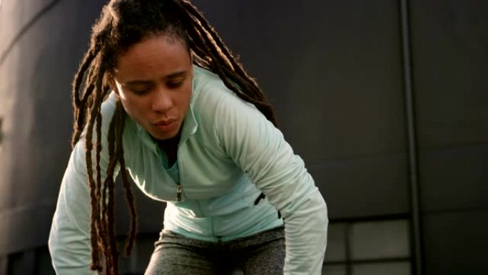 年轻的非洲裔美国妇女在4k城市锻炼后休息的前视图