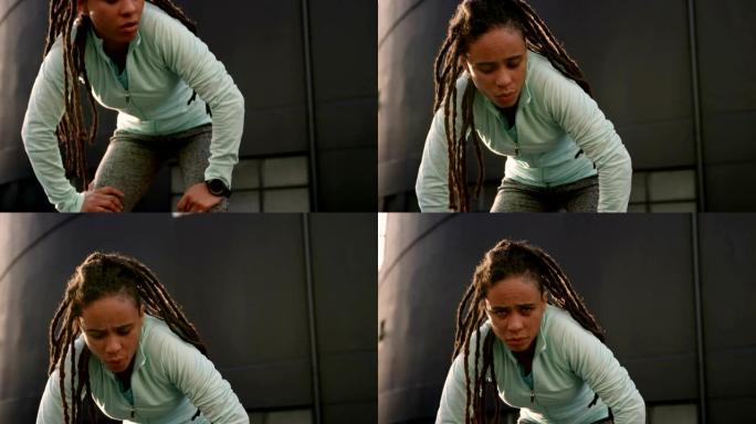 年轻的非洲裔美国妇女在4k城市锻炼后休息的前视图
