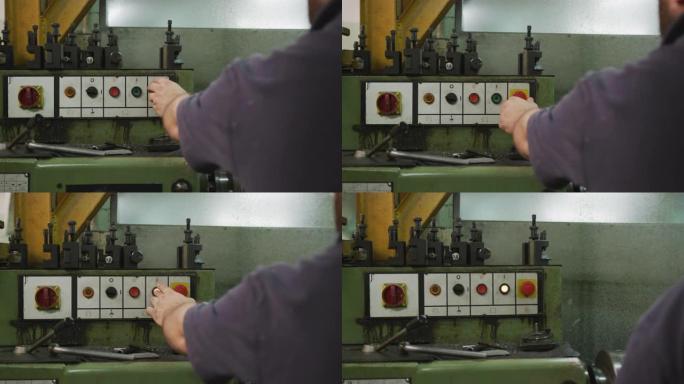 高加索男性工厂工人按下按钮并打开机器