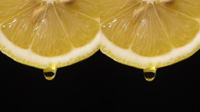 垂直和慢动作: 柠檬片上的一滴液体在黑色上